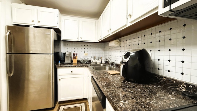 kitchen featuring decorative backsplash, white cabinetry, and stainless steel appliances