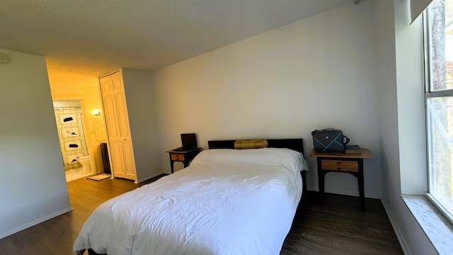 bedroom with a textured ceiling and dark hardwood / wood-style floors