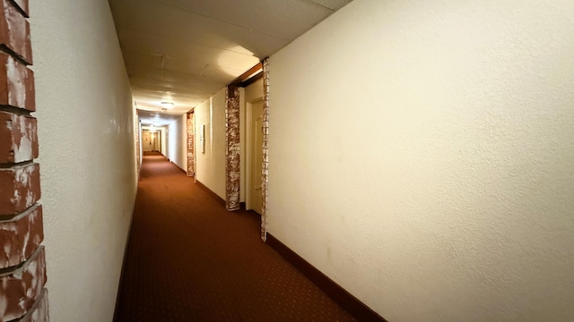 hallway with dark colored carpet