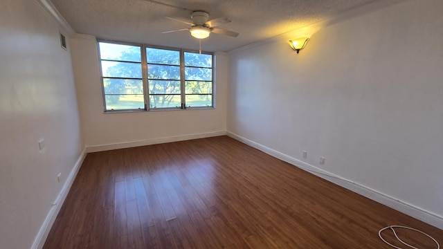 spare room featuring a textured ceiling, ceiling fan, crown molding, and dark hardwood / wood-style floors