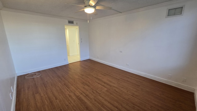 unfurnished room featuring a textured ceiling, dark hardwood / wood-style flooring, and crown molding