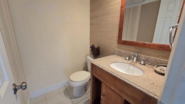 bathroom with toilet, vanity, and tile patterned floors