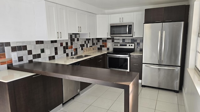 kitchen with sink, decorative backsplash, dark brown cabinetry, white cabinetry, and stainless steel appliances