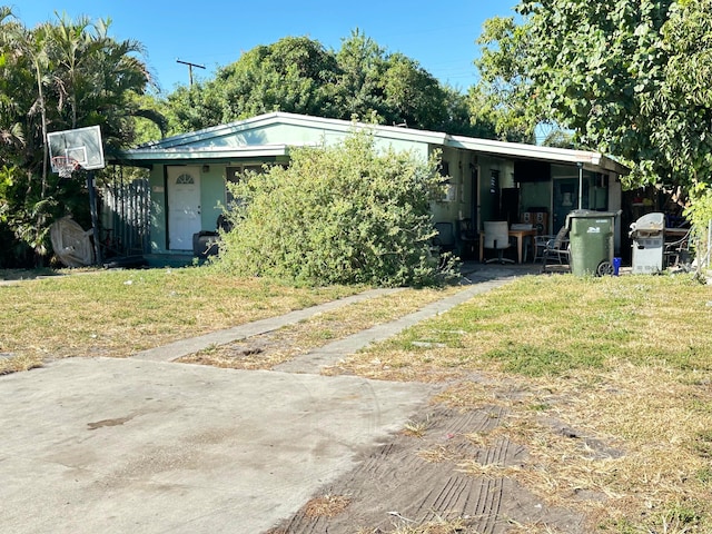 view of front of property featuring a carport and a front lawn