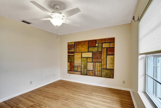 unfurnished room featuring ceiling fan, a textured ceiling, and light wood-type flooring