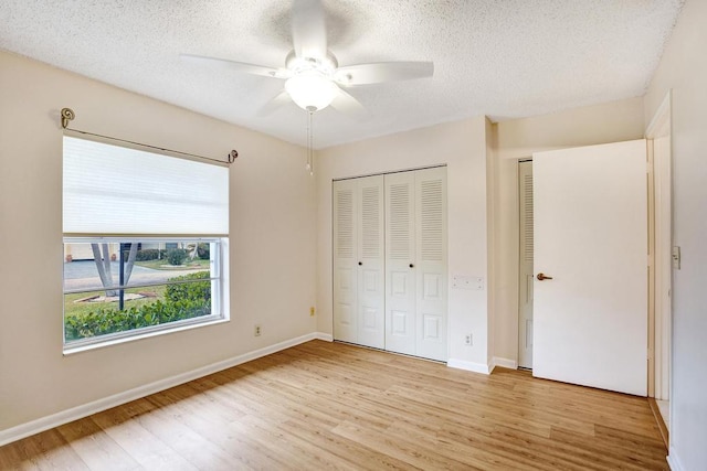 unfurnished bedroom with a textured ceiling, light hardwood / wood-style flooring, and ceiling fan