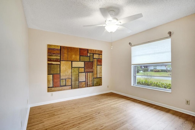 empty room featuring ceiling fan, light hardwood / wood-style floors, and a textured ceiling