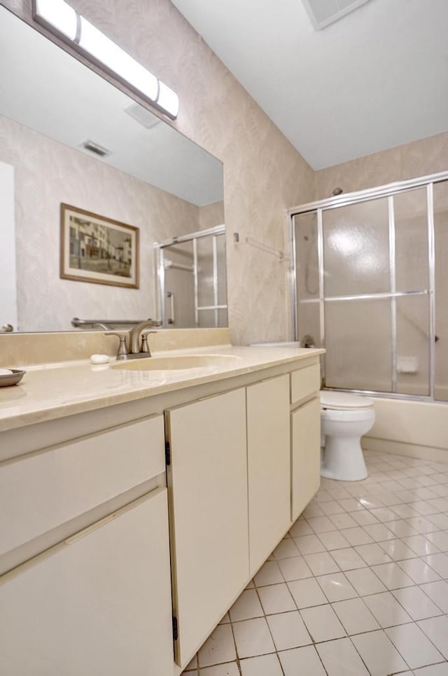 full bathroom with tile patterned flooring, vanity, enclosed tub / shower combo, and toilet