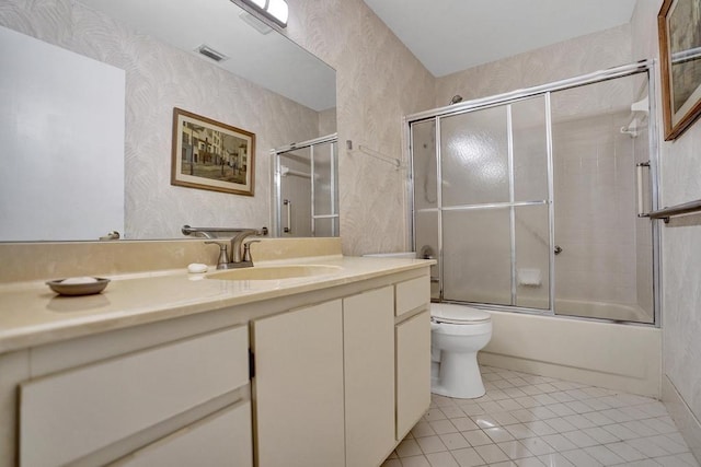 full bathroom featuring tile patterned floors, vanity, enclosed tub / shower combo, and toilet