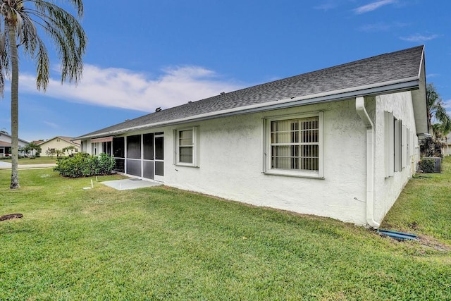 rear view of house featuring a sunroom and a yard