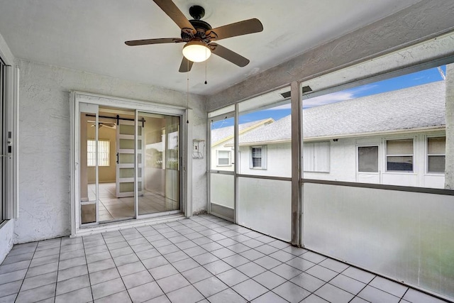 unfurnished sunroom featuring ceiling fan