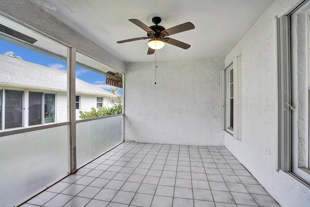 unfurnished sunroom with ceiling fan