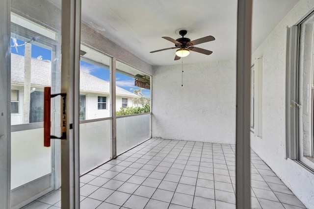 unfurnished sunroom with ceiling fan