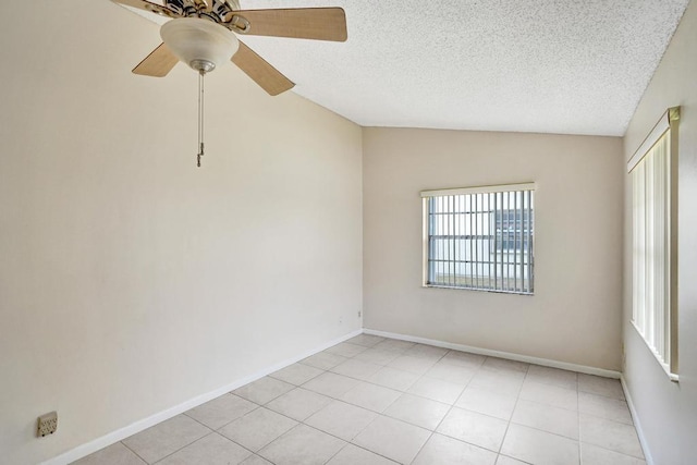 unfurnished room with ceiling fan, lofted ceiling, a textured ceiling, and light tile patterned floors