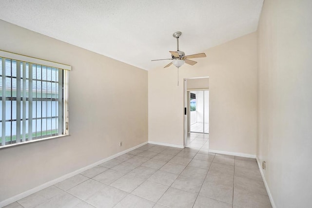 tiled empty room featuring a textured ceiling and ceiling fan