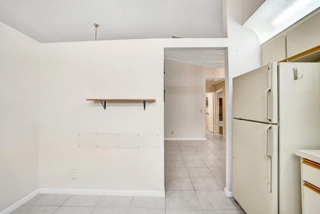 kitchen with light tile patterned floors and white fridge