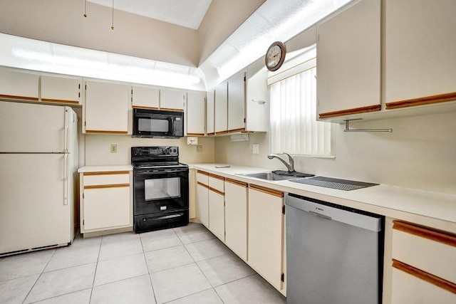 kitchen featuring white cabinets, light tile patterned floors, sink, and black appliances