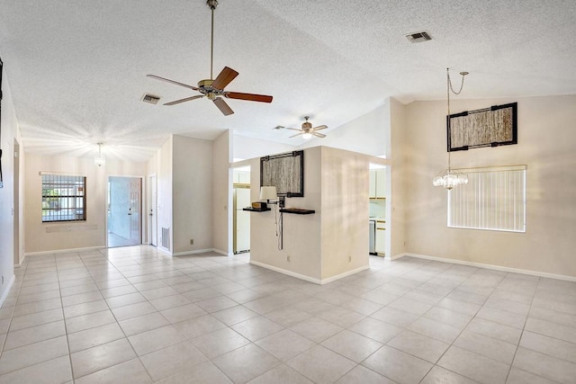 unfurnished living room featuring a textured ceiling, light tile patterned floors, ceiling fan with notable chandelier, and vaulted ceiling