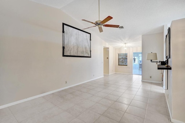 spare room with light tile patterned floors, a textured ceiling, vaulted ceiling, and ceiling fan