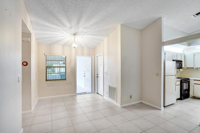 foyer entrance with a textured ceiling and light tile patterned flooring