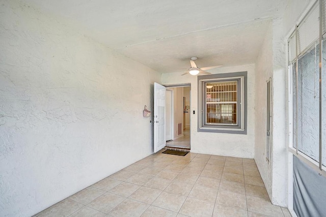 unfurnished room featuring ceiling fan and light tile patterned floors