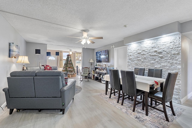 living room featuring a textured ceiling, light hardwood / wood-style floors, and ceiling fan