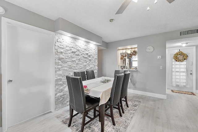 dining area featuring a textured ceiling, light hardwood / wood-style flooring, and ceiling fan