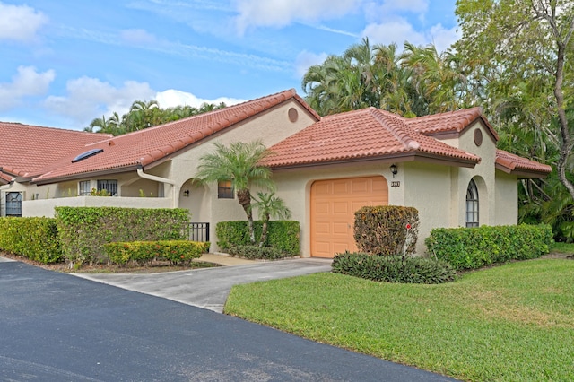 mediterranean / spanish home with a front yard and a garage