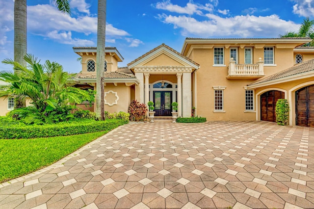 mediterranean / spanish home featuring a balcony and french doors