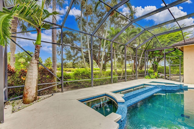 view of swimming pool featuring glass enclosure and an in ground hot tub