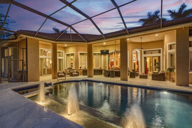 pool at dusk featuring french doors, a lanai, outdoor lounge area, ceiling fan, and a patio