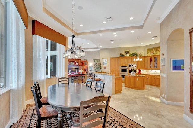 dining room featuring a chandelier, crown molding, and a tray ceiling