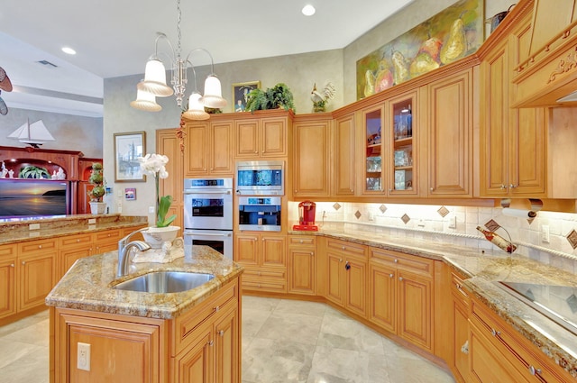 kitchen with pendant lighting, a center island with sink, sink, appliances with stainless steel finishes, and a chandelier