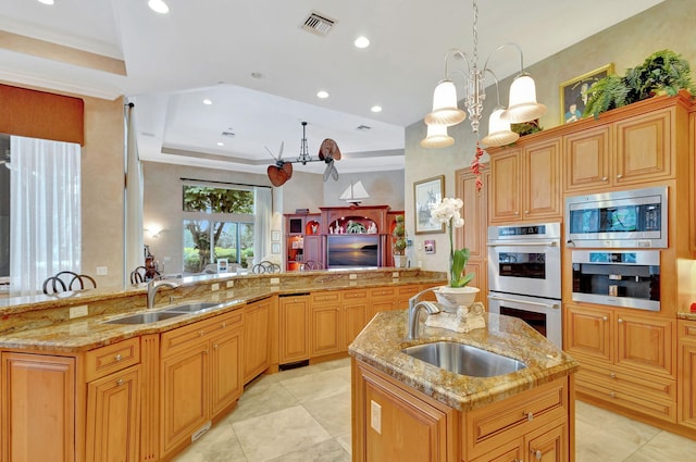 kitchen featuring stainless steel appliances, a center island with sink, and sink