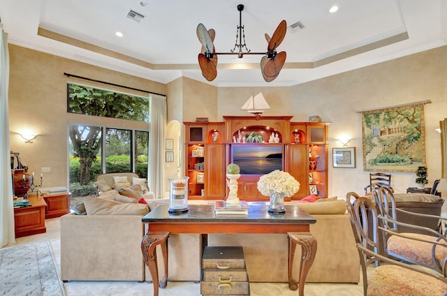 living room with a tray ceiling, ceiling fan, and crown molding