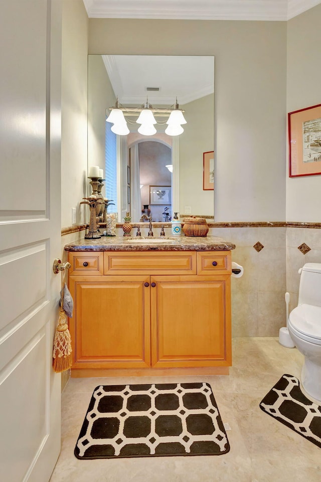 bathroom featuring toilet, crown molding, and tile walls