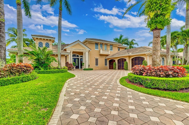 mediterranean / spanish home with a garage and a front lawn