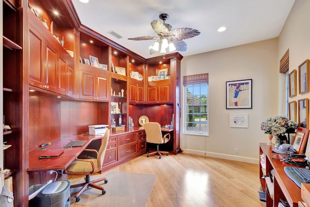 office featuring built in desk, light hardwood / wood-style flooring, and ceiling fan