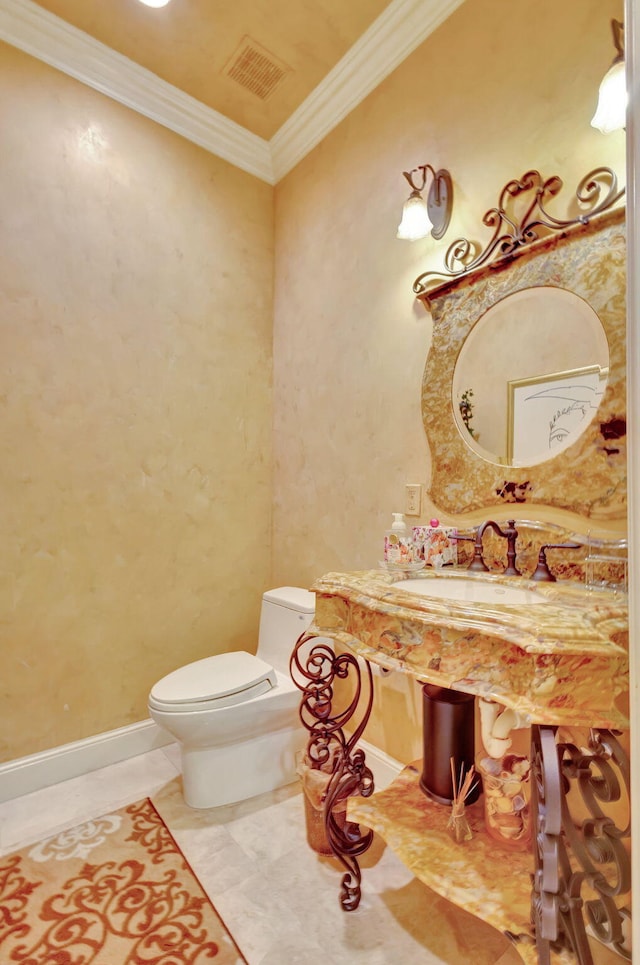 bathroom with tile patterned floors, toilet, crown molding, and sink