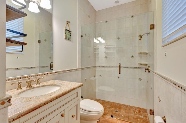 bathroom with vanity, toilet, tile walls, and walk in shower