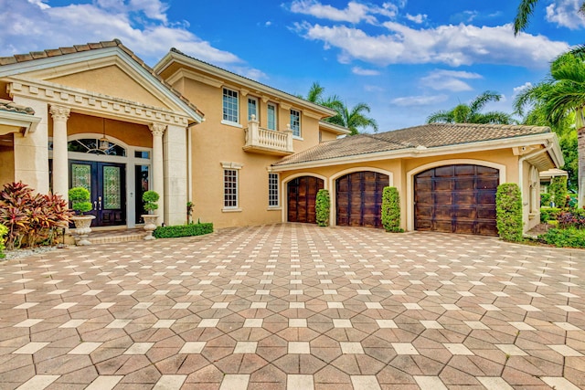 mediterranean / spanish-style house featuring french doors, a balcony, and a garage