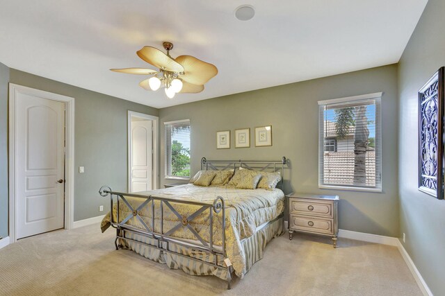 carpeted bedroom with multiple windows and ceiling fan