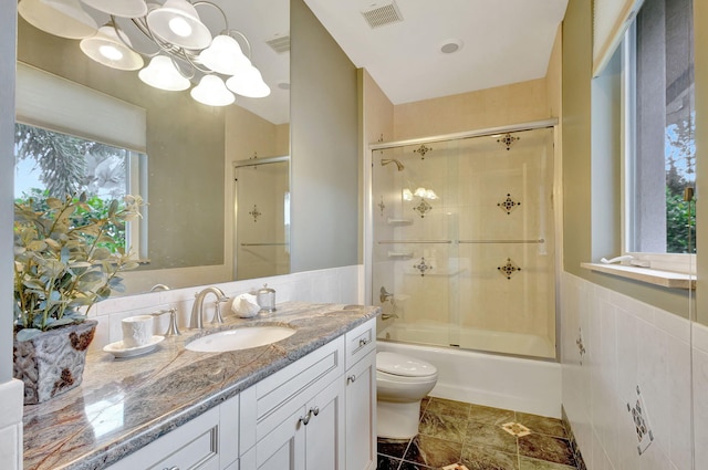 full bathroom featuring toilet, vanity, and combined bath / shower with glass door