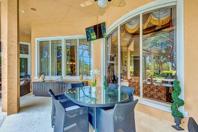 view of patio featuring ceiling fan and a lanai