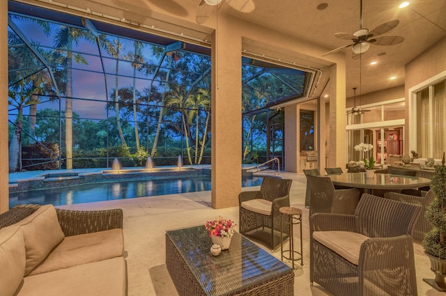 exterior space with a lanai, a patio area, ceiling fan, and an in ground hot tub