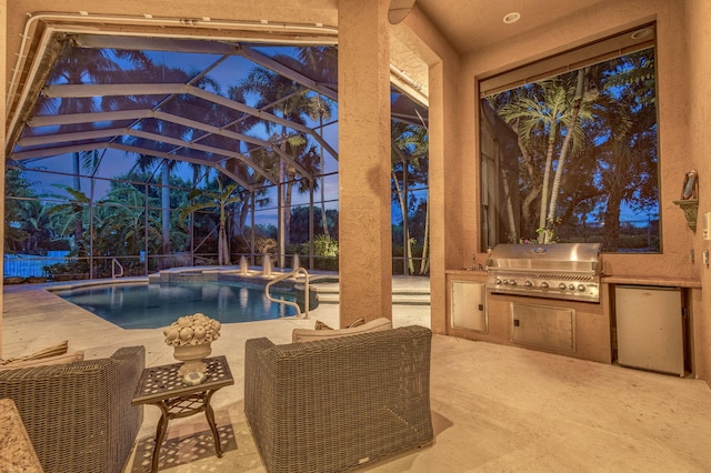 pool at dusk with an outdoor kitchen, a patio, grilling area, and a lanai