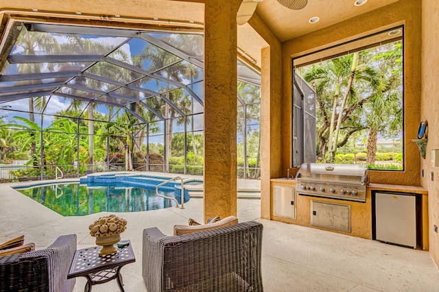 view of swimming pool with a lanai, an in ground hot tub, area for grilling, a patio area, and exterior kitchen