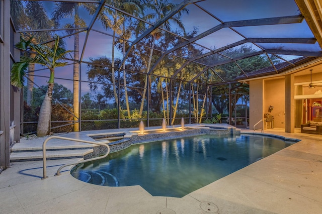 pool at dusk featuring a lanai, a patio area, and an in ground hot tub