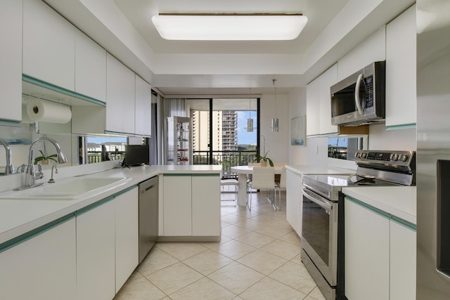 kitchen with white cabinetry, sink, stainless steel appliances, kitchen peninsula, and light tile patterned flooring