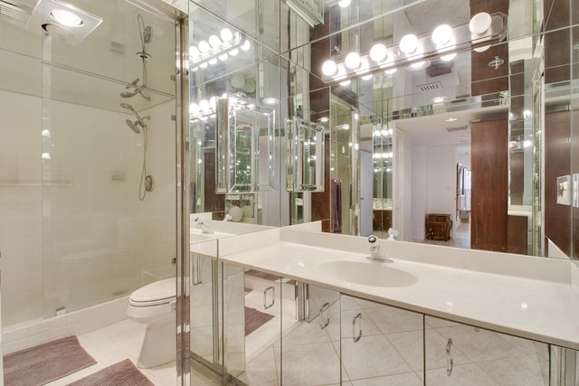 bathroom with tile patterned floors, toilet, a shower with door, and sink